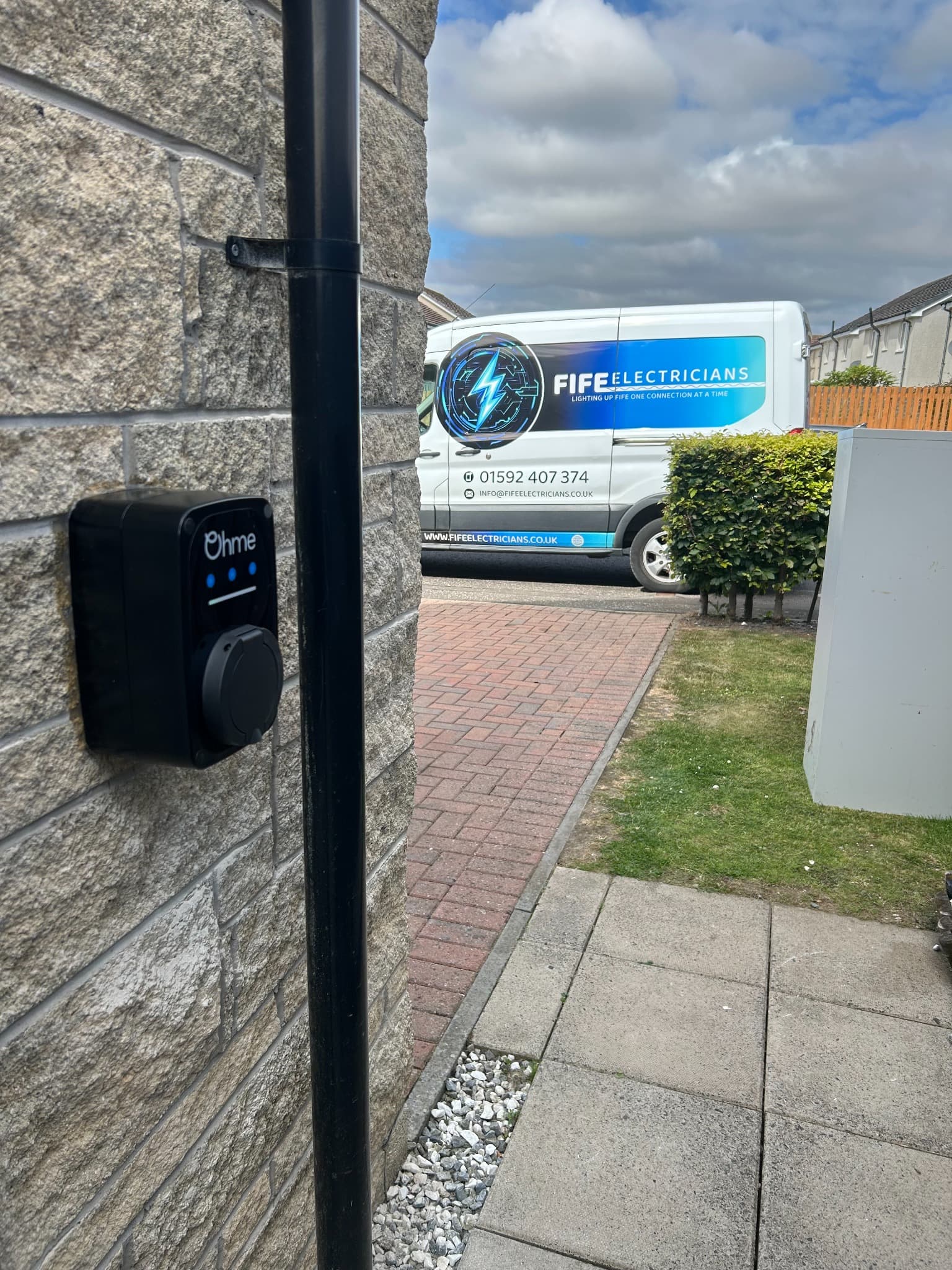 OHME EV charger installed beside a home with a Fife Electricians van in view
